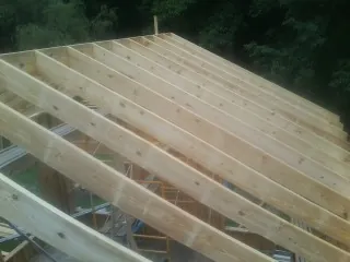 New roof rafters set over an addition before sheathing in Coldwater